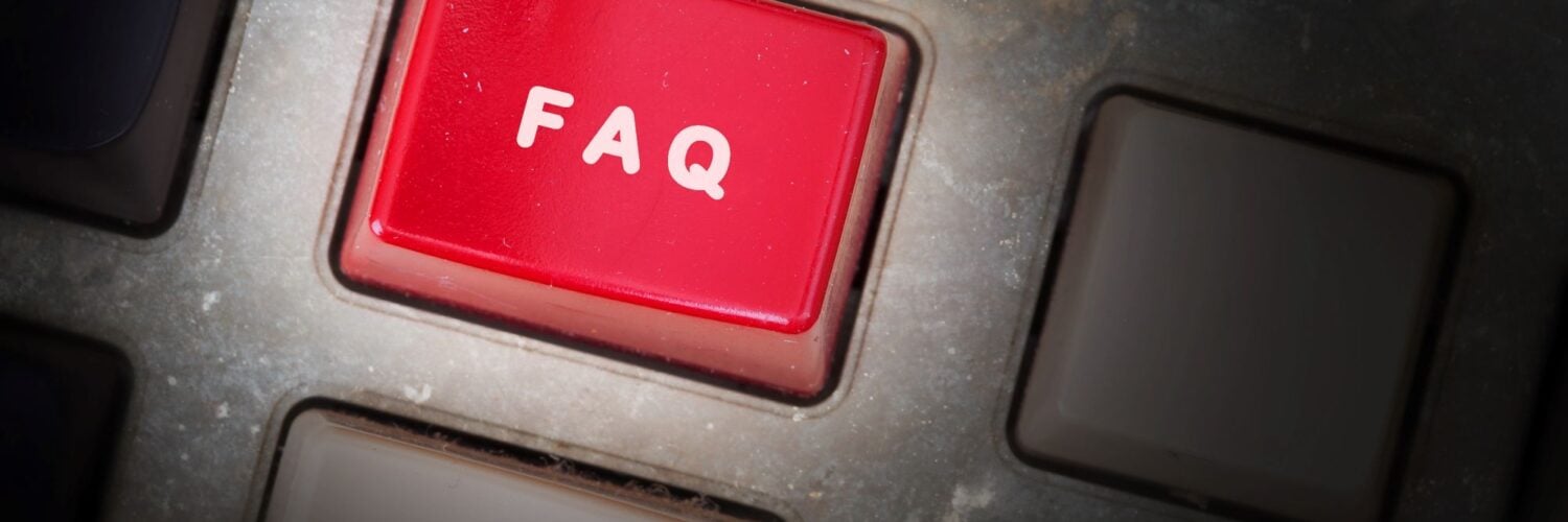 Stock image of closeup of black keyboard with red button reading "FAQ."